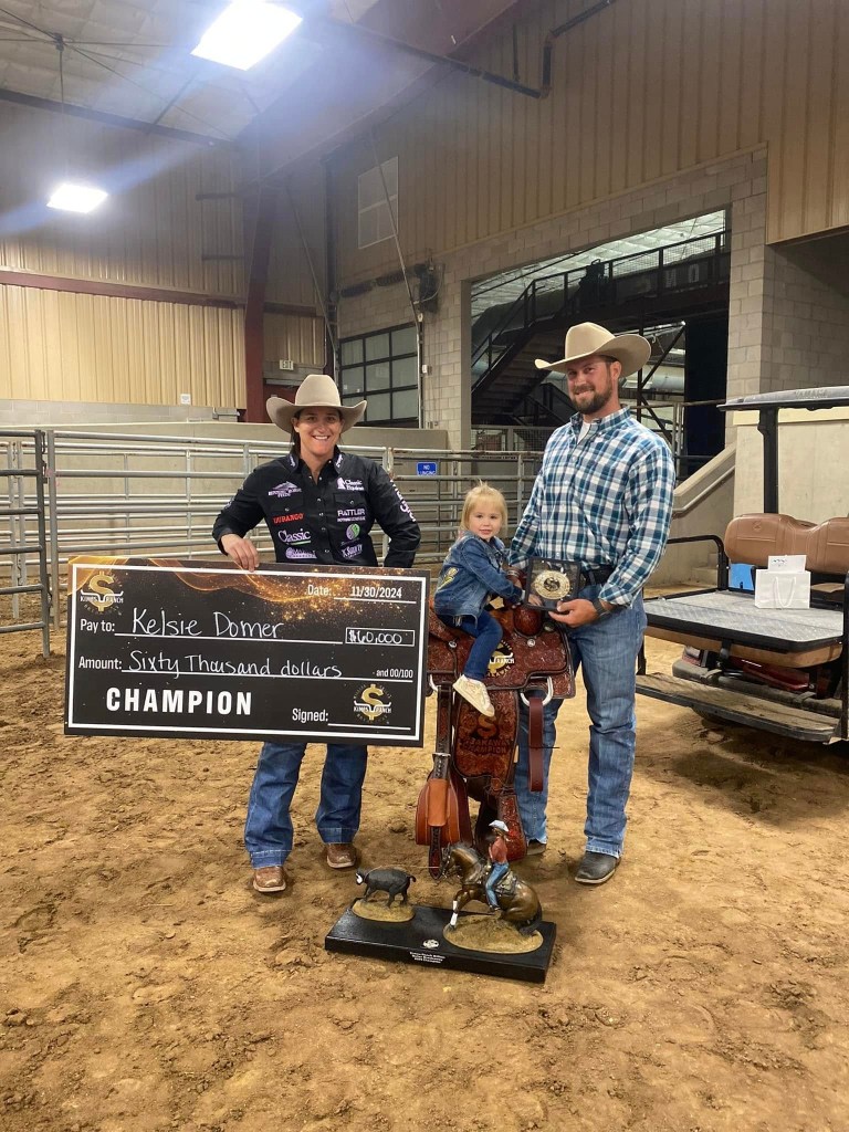 Rodeo star Kelsie Domer and her husband Ryan with their daughter Oaklynn celebrating Domer's championship win.