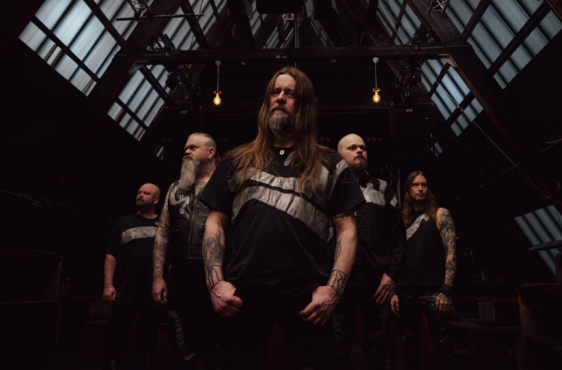 The five members of Enslaved beneath a glass-and-steel roof in their Mið promotional photograph