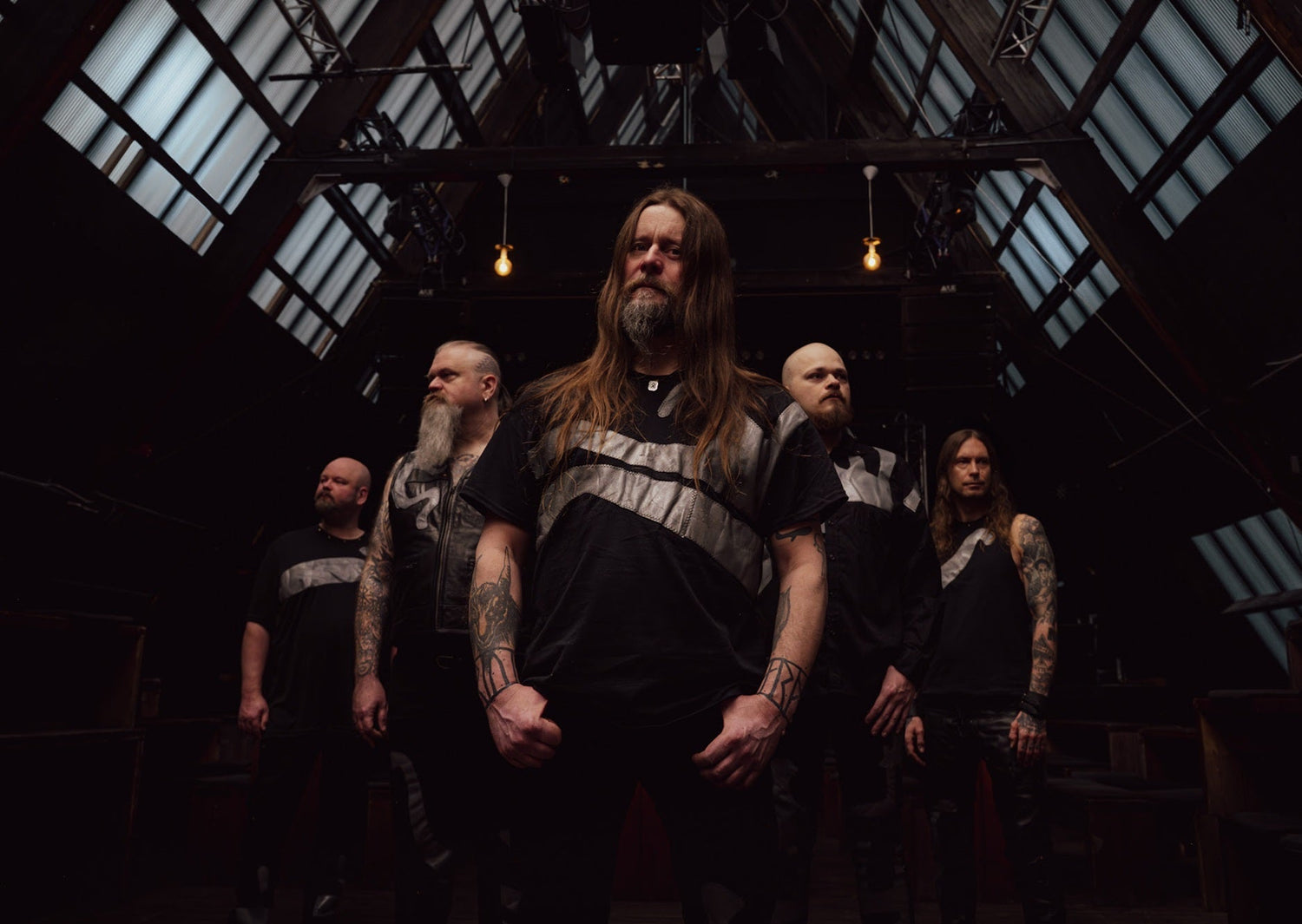 The five members of Enslaved beneath a glass-and-steel roof in their Mið promotional photograph