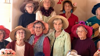 Santa Fe Raging Grannies performing a protest song in shawls, floral aprons and elaborate hats