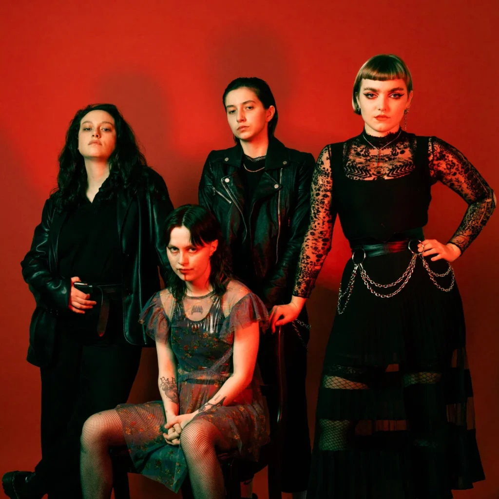The members of Witch Fever in a red-toned promotional portrait